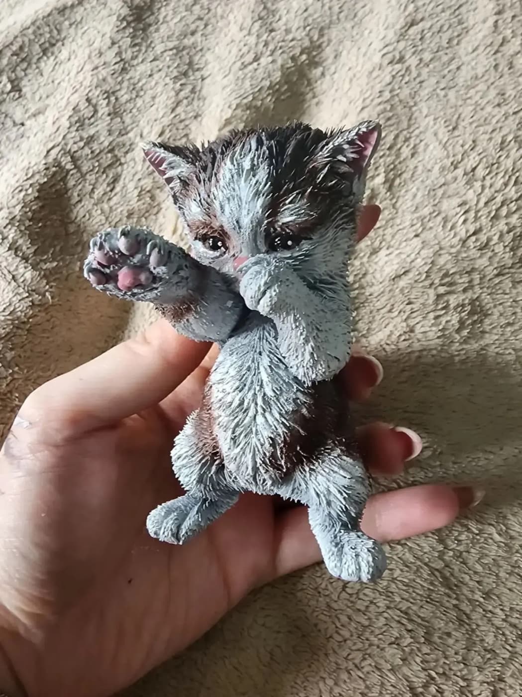 Покрашенная подарочная фигурка котёнка из мема в руке
